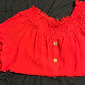 Red off the shoulder blouse with 3/4 sleeves.